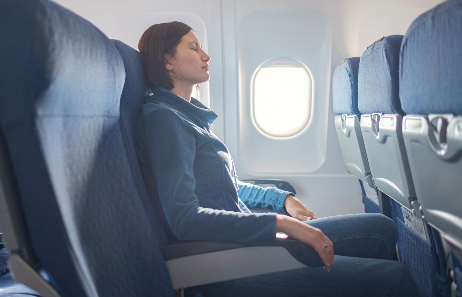 Femme en avion les yeux fermés souffrant du mal des transports