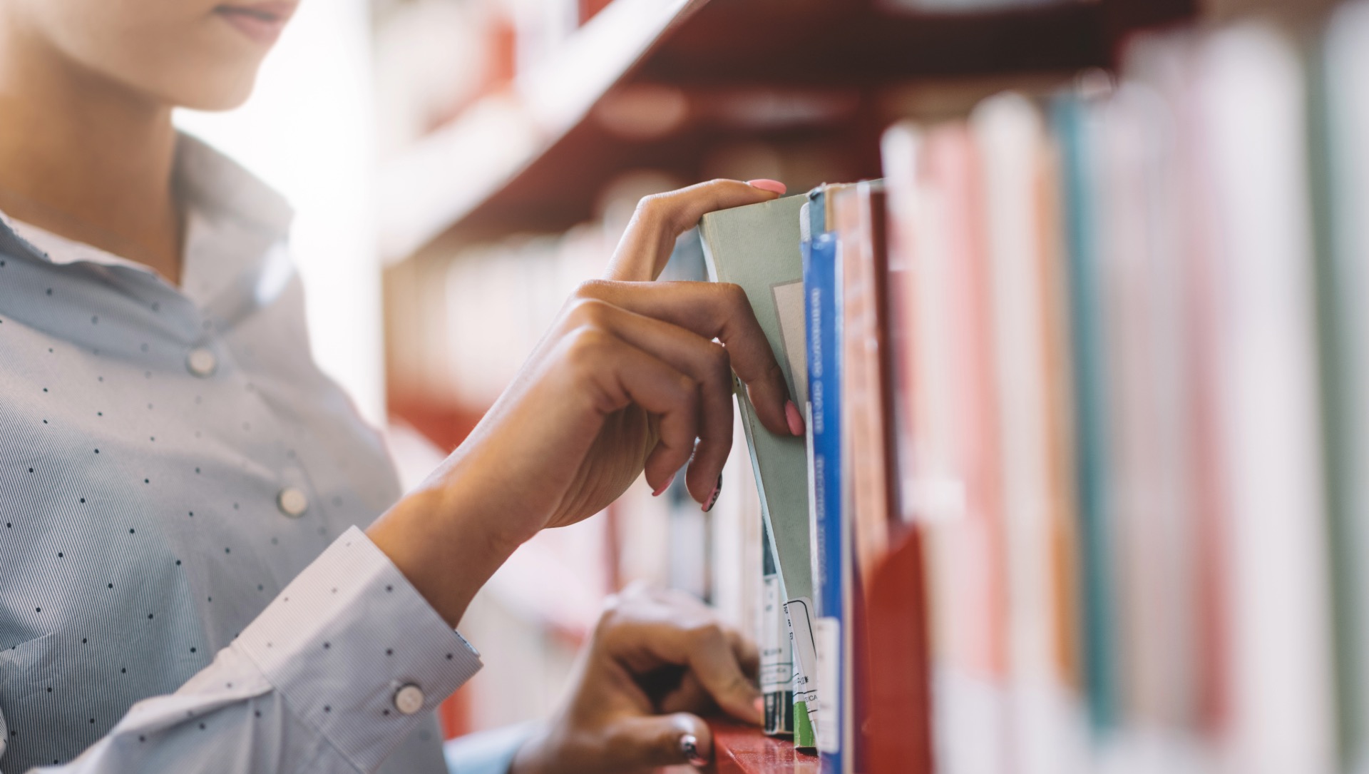 Mains parcourant un livre en bibliothèque — littérature scientifique en physiothérapie vestibulaire