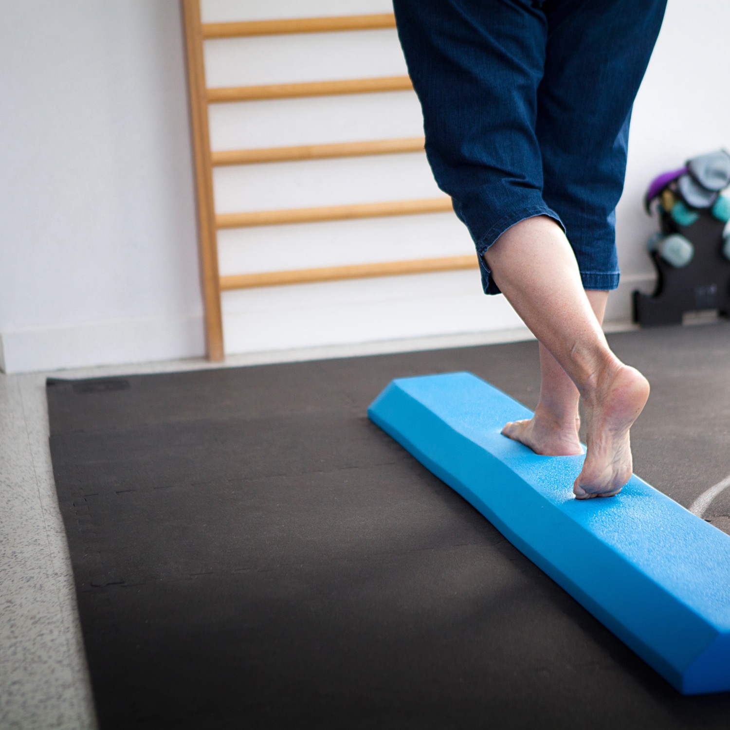 Patiente s'exerçant sur une poutre d'équilibre lors d'une séance de rééducation vestibulaire